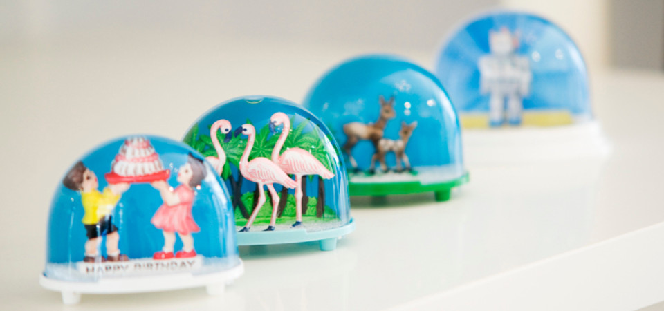 Vier Schneekugeln mit Motiven im 50er Jahre Stil